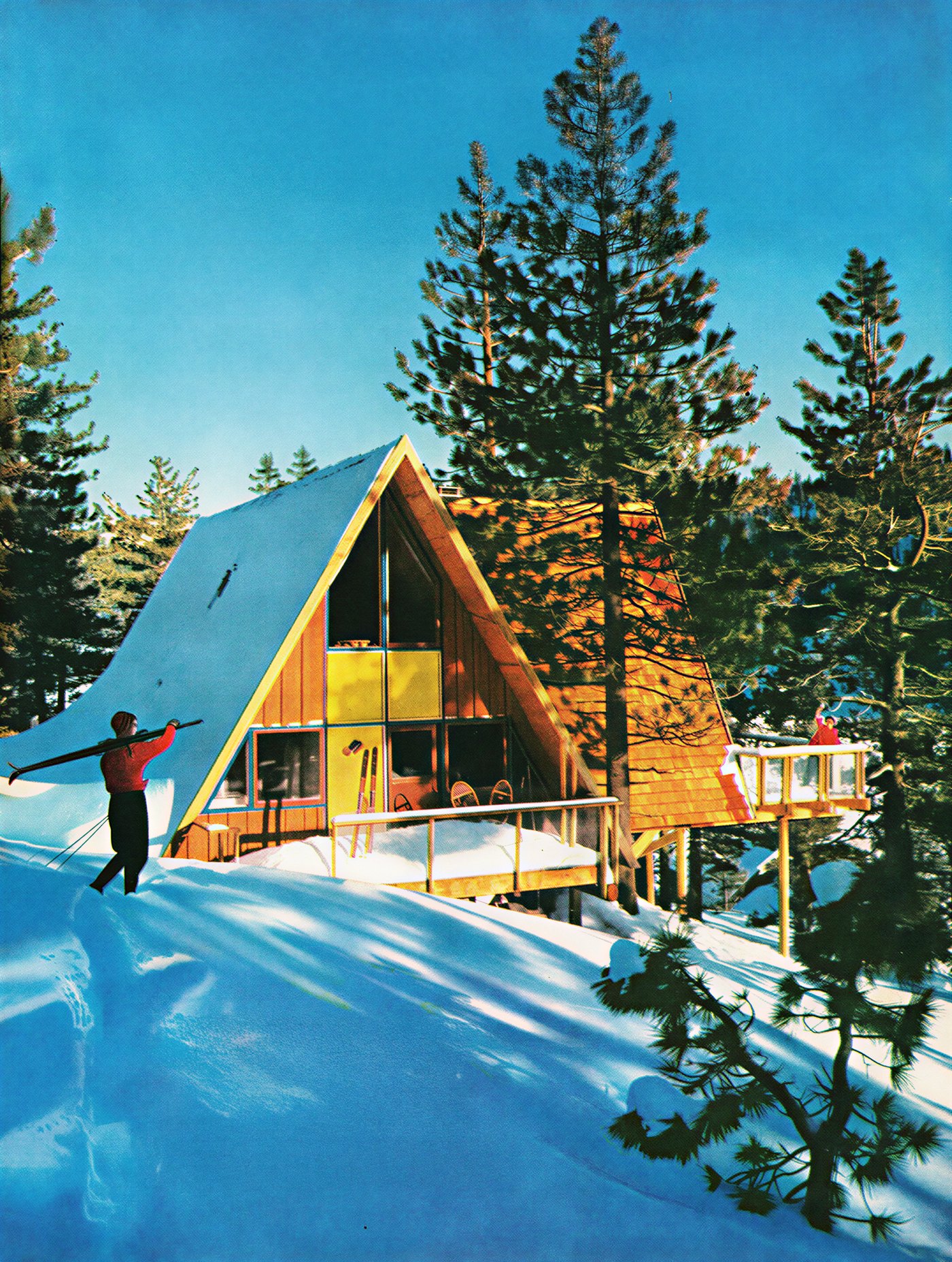 1957 magazine cover photo of a yellow A-frame cabin in the snow with a skier walking past